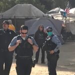 Police in houseless encampment.